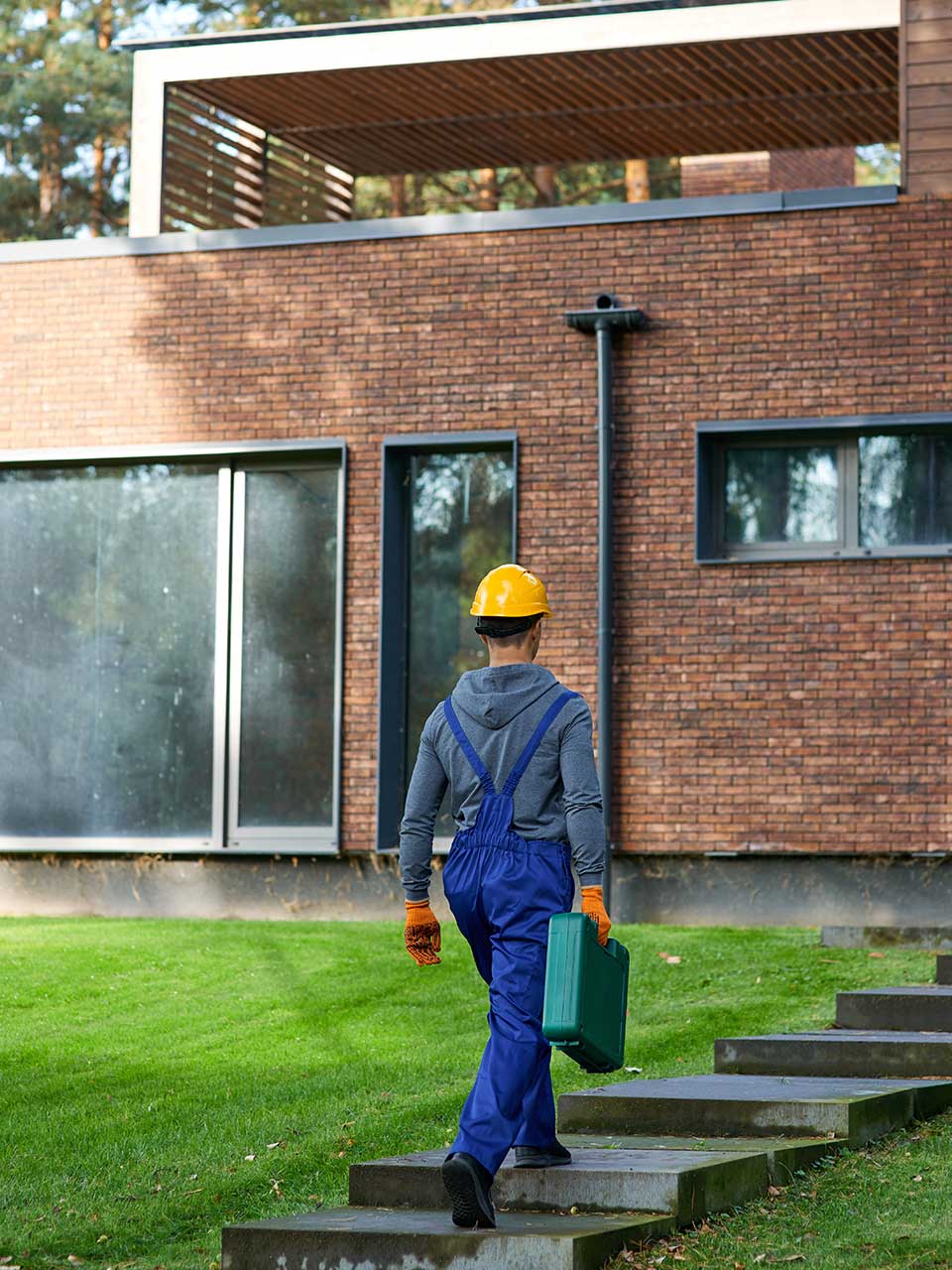 construction worker carrying a toolbox walking up a set of stairs